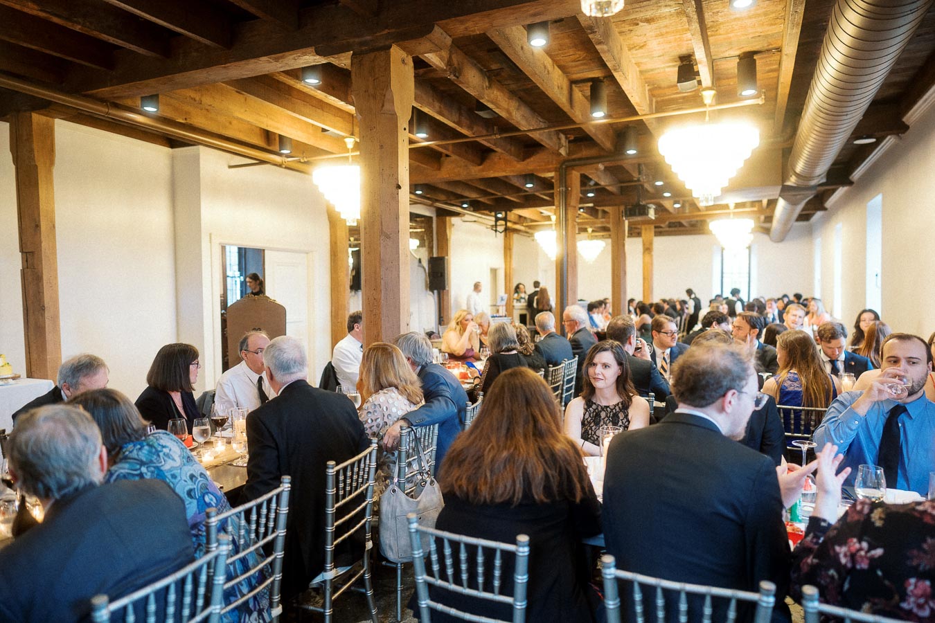 Guests seated at long tables during an indoor reception dinner