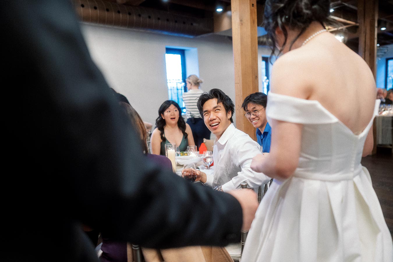 Bride greeting seated guests at an indoor reception table