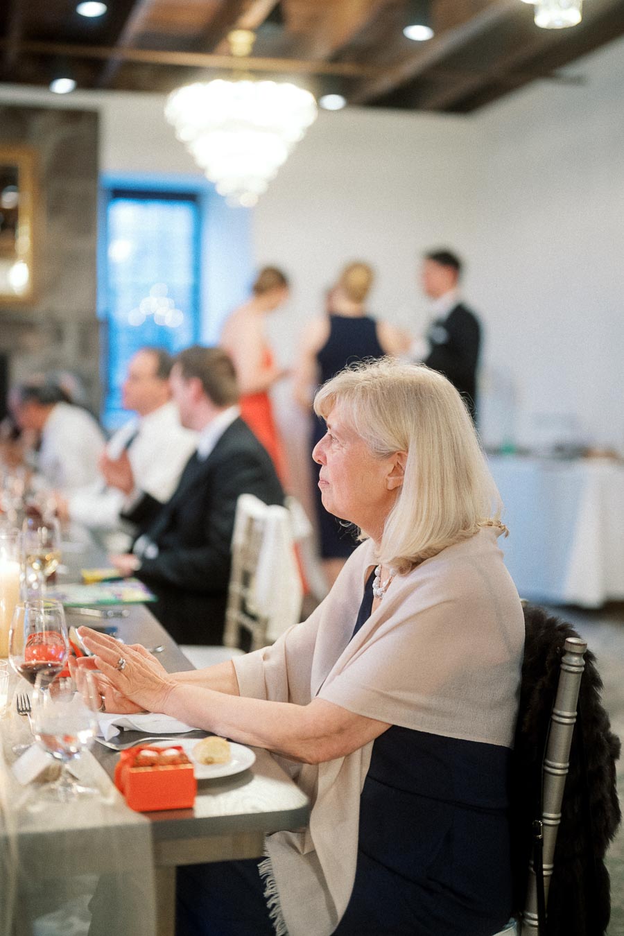 Woman seated at a decorated reception table during an indoor celebration