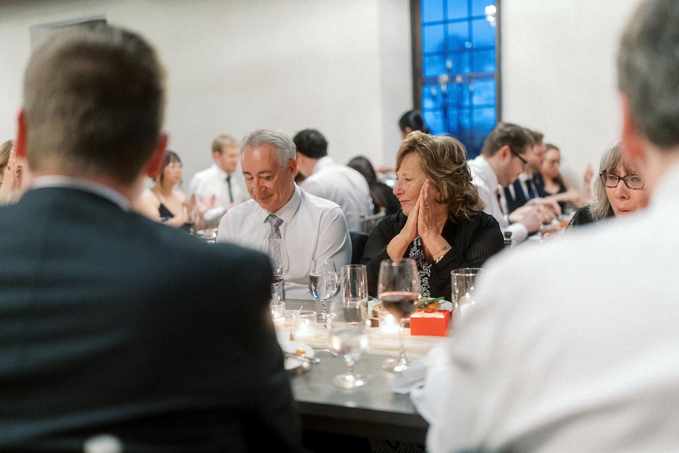 Guests seated at a candlelit dinner table during a formal celebration