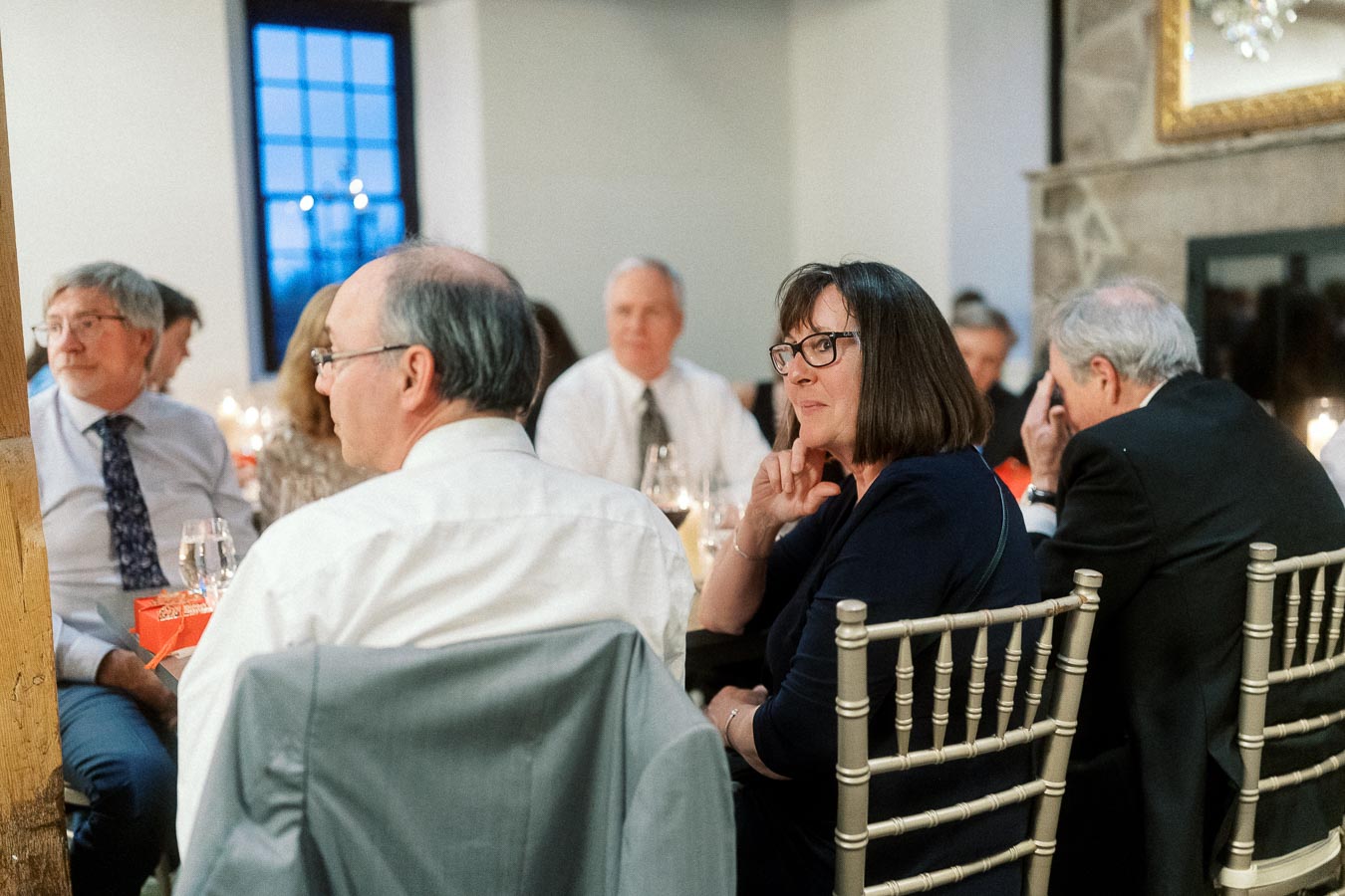 Guests seated at a candlelit dinner table during an engagement celebration