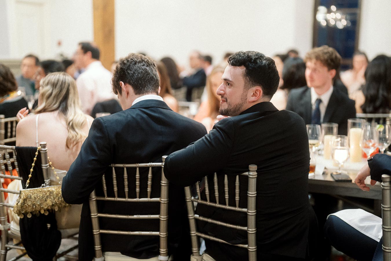 Guests in formalwear seated at round tables during an indoor event