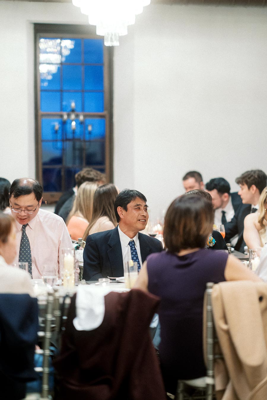 Guests seated at a formal dinner table during an engagement celebration