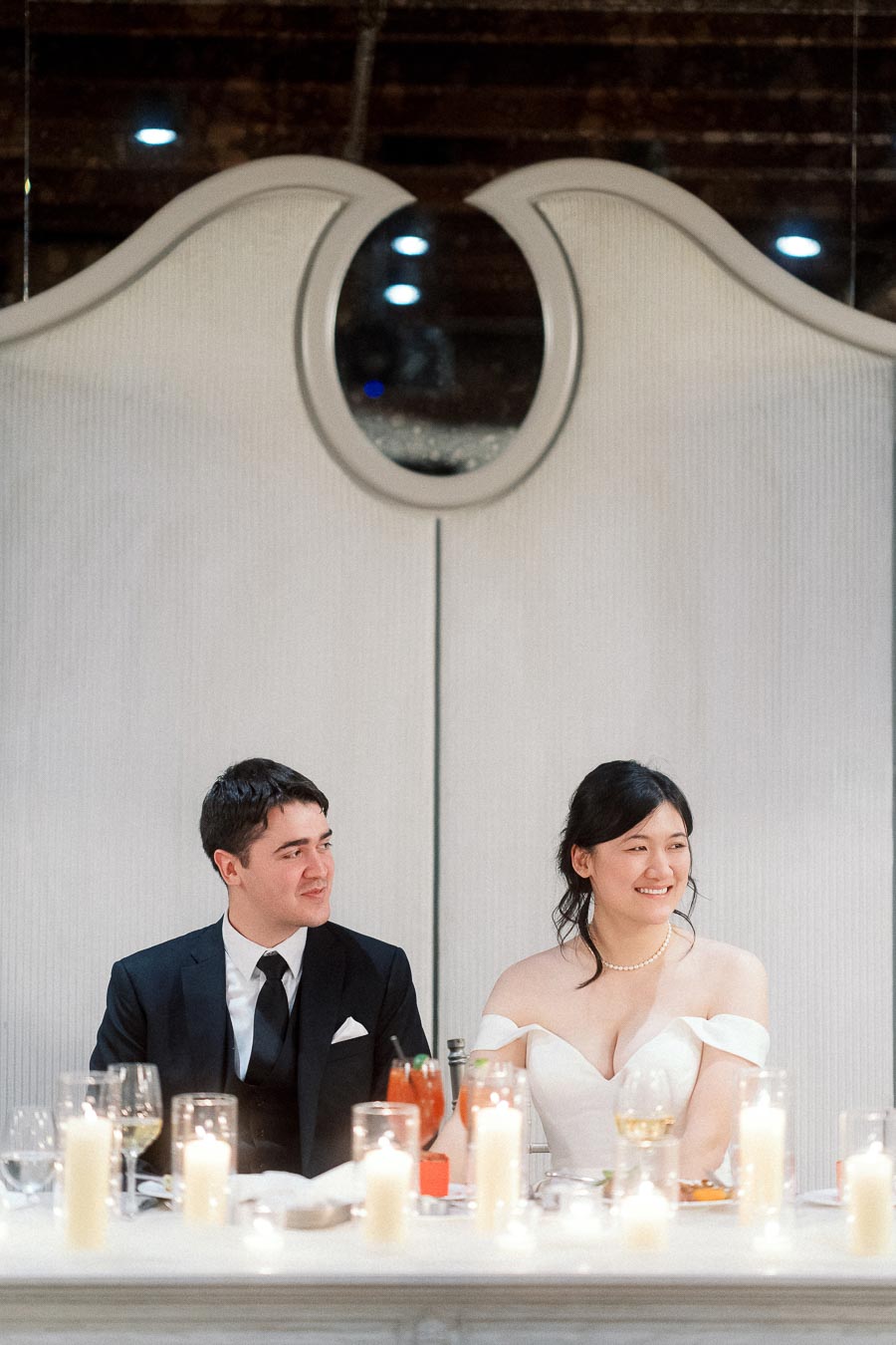 Couple seated at a candlelit table during an elegant engagement celebration