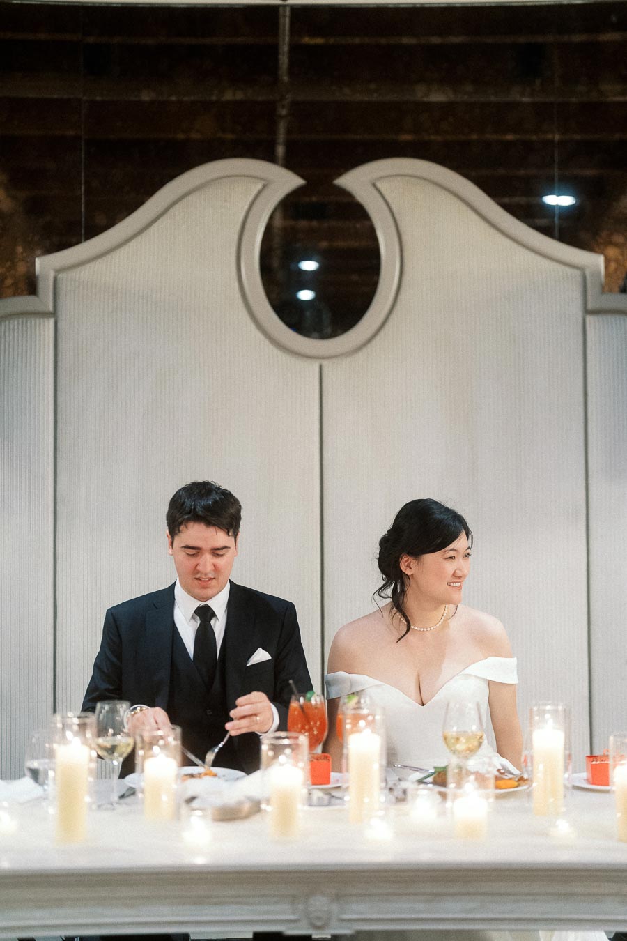 Engaged couple seated at a candlelit reception table during an engagement photoshoot