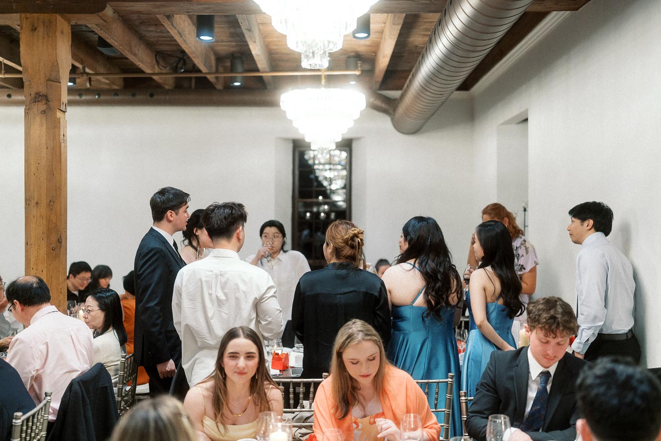 Guests mingle and dine at a formal indoor engagement celebration.