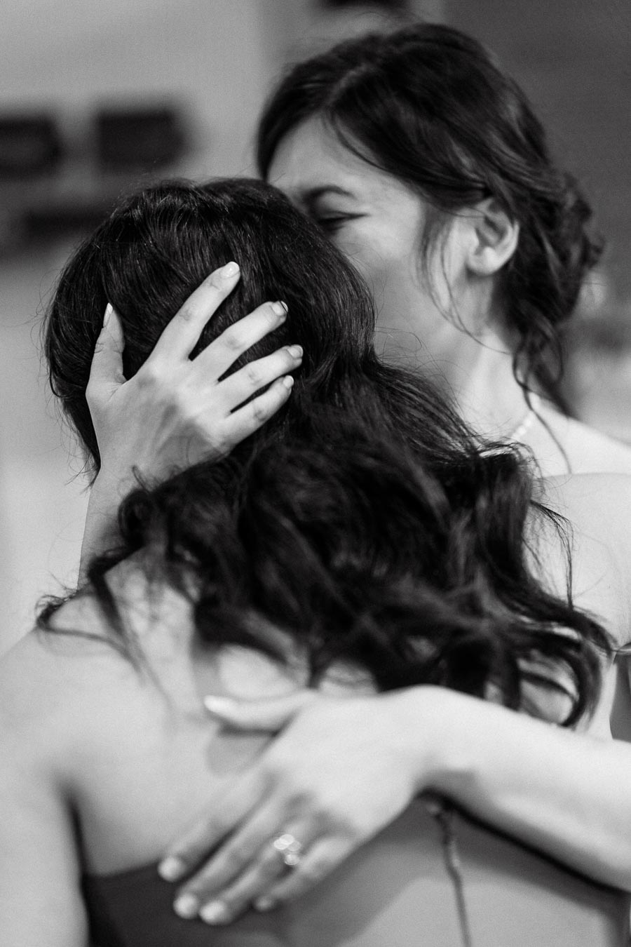 Black-and-white close-up of two women embracing during an engagement photoshoot