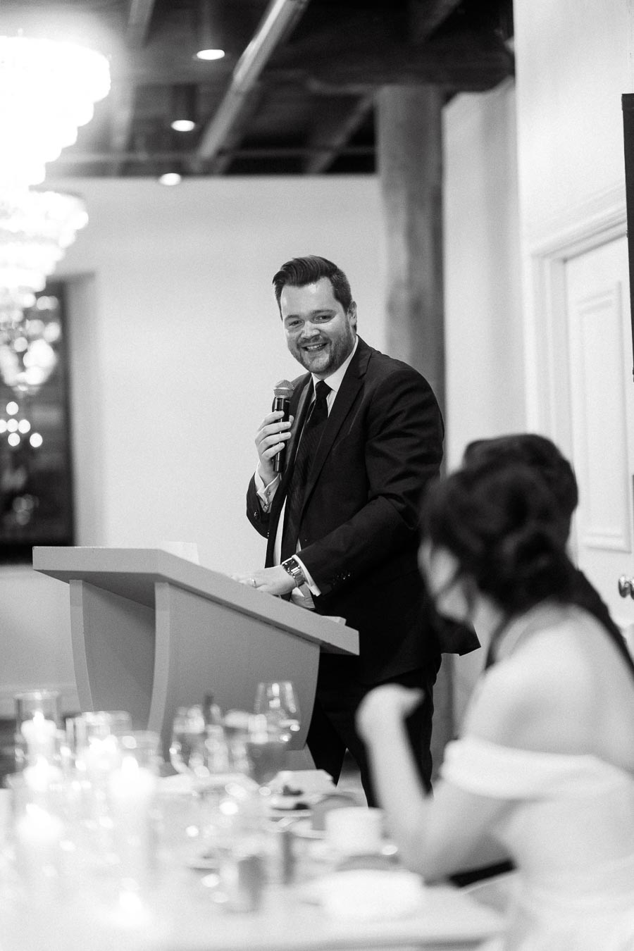 Man in a suit gives a speech at a reception podium