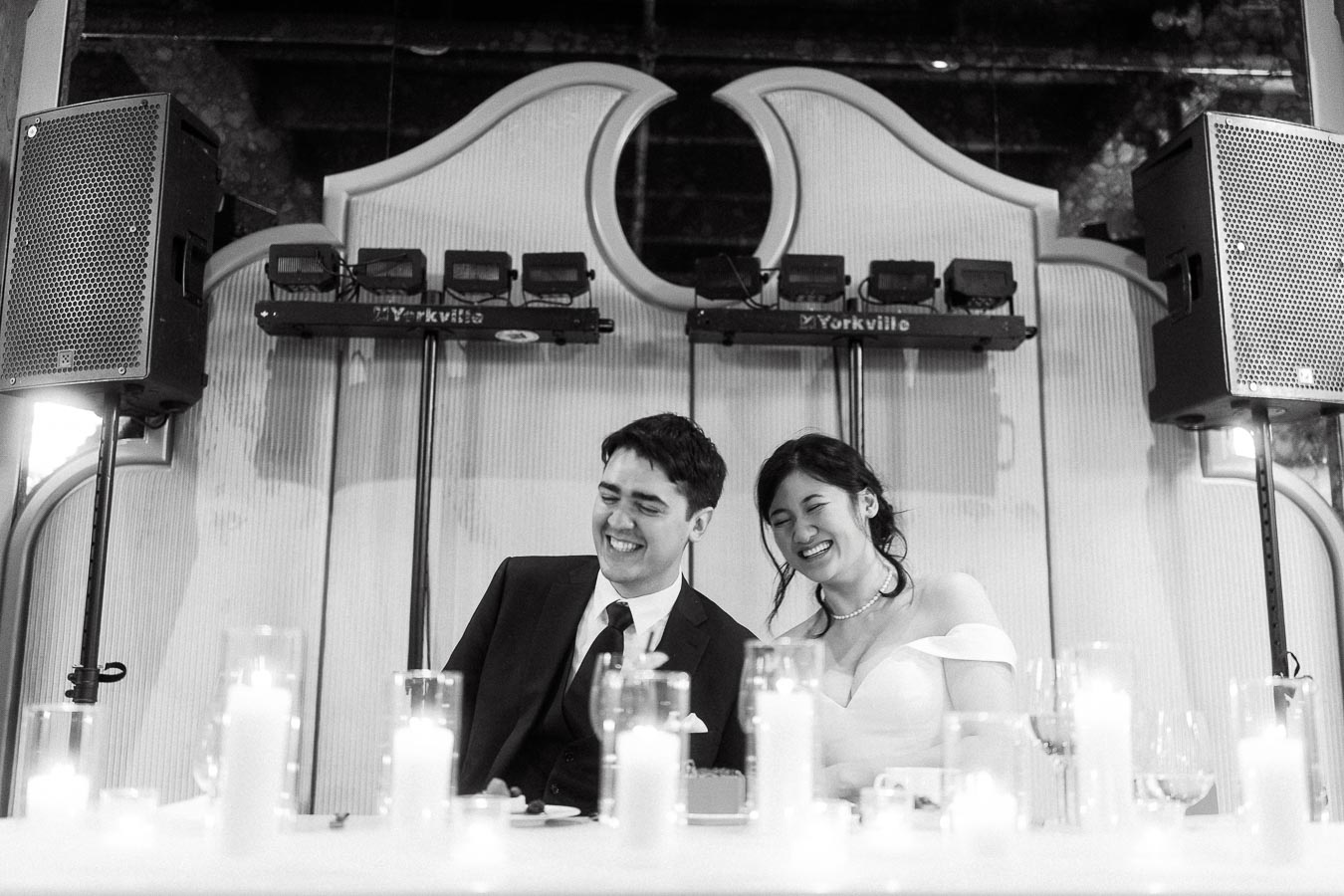Couple laughing together at a candlelit table during an engagement celebration