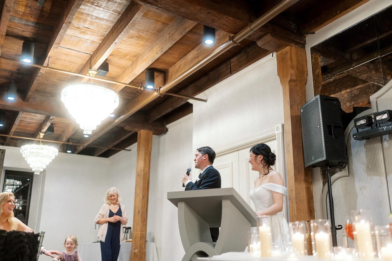 Couple standing at a podium giving a speech during an indoor reception