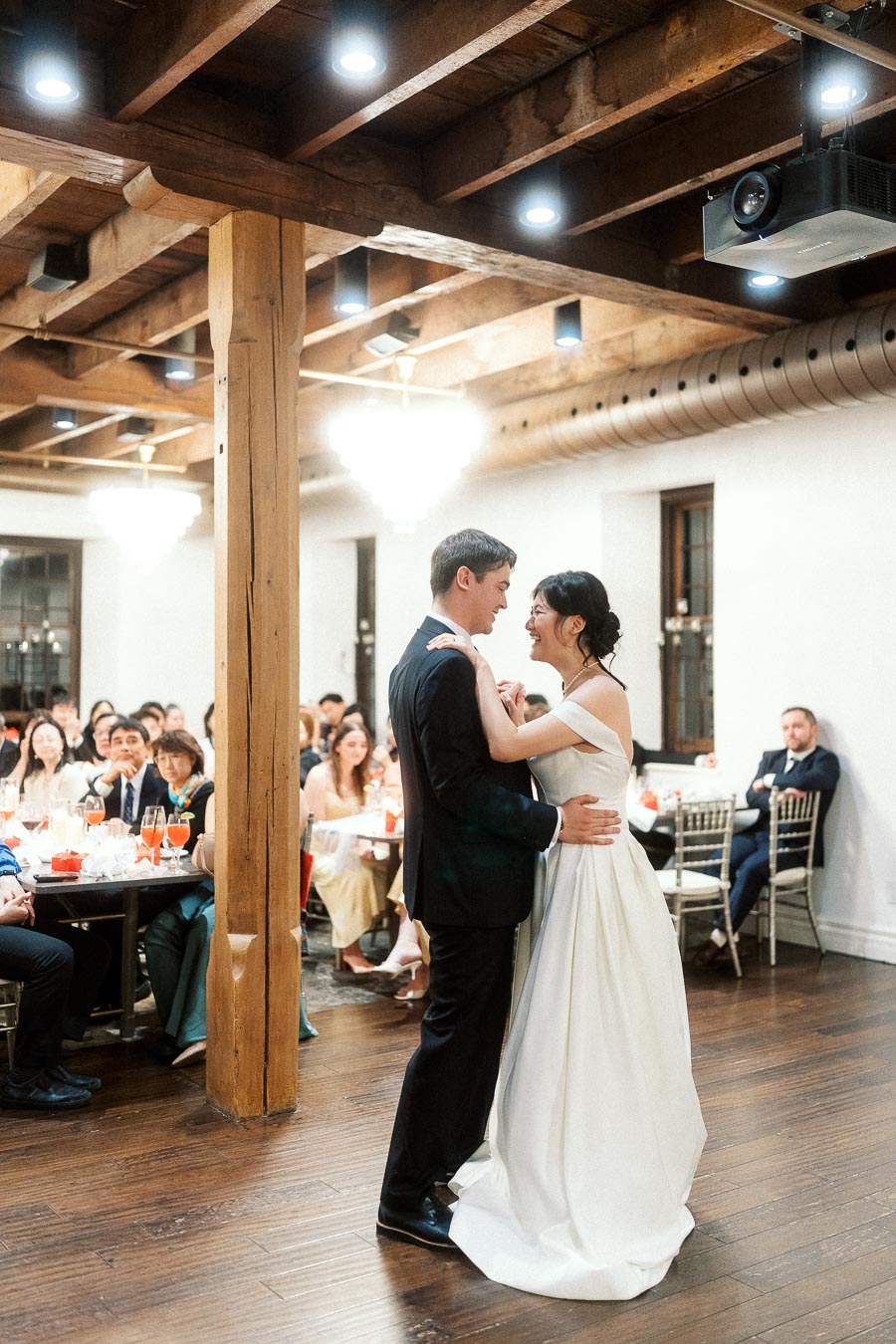 Couple dancing together in formal attire during an indoor reception