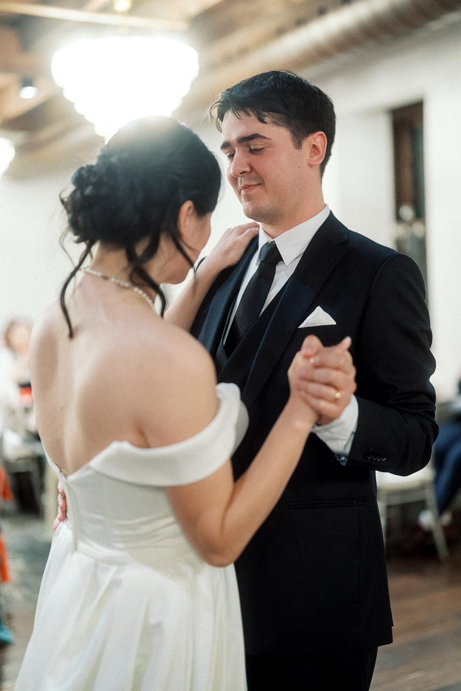 Couple in formal attire slow dancing indoors during an intimate celebration