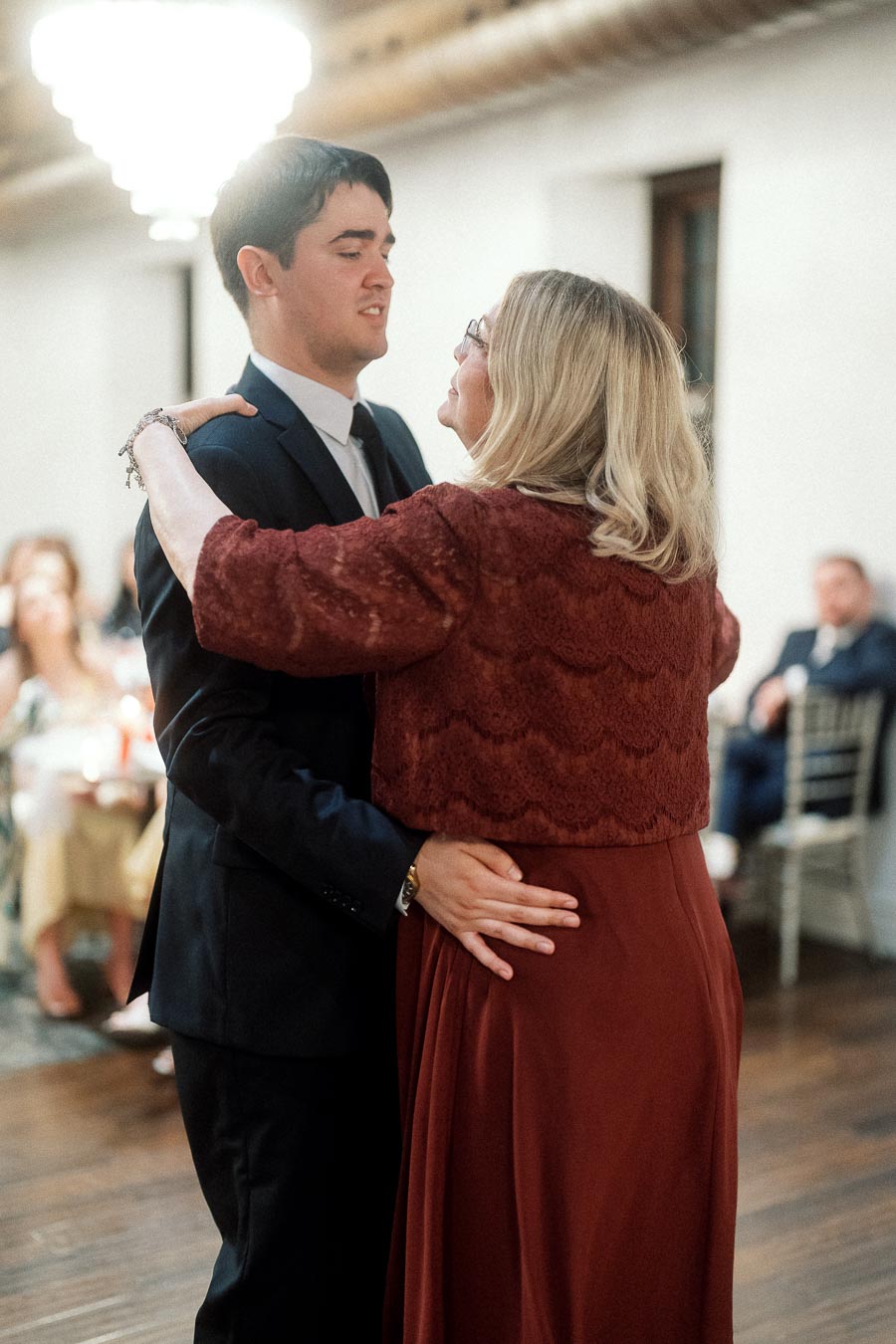 Couple slow dancing together indoors during a formal celebration