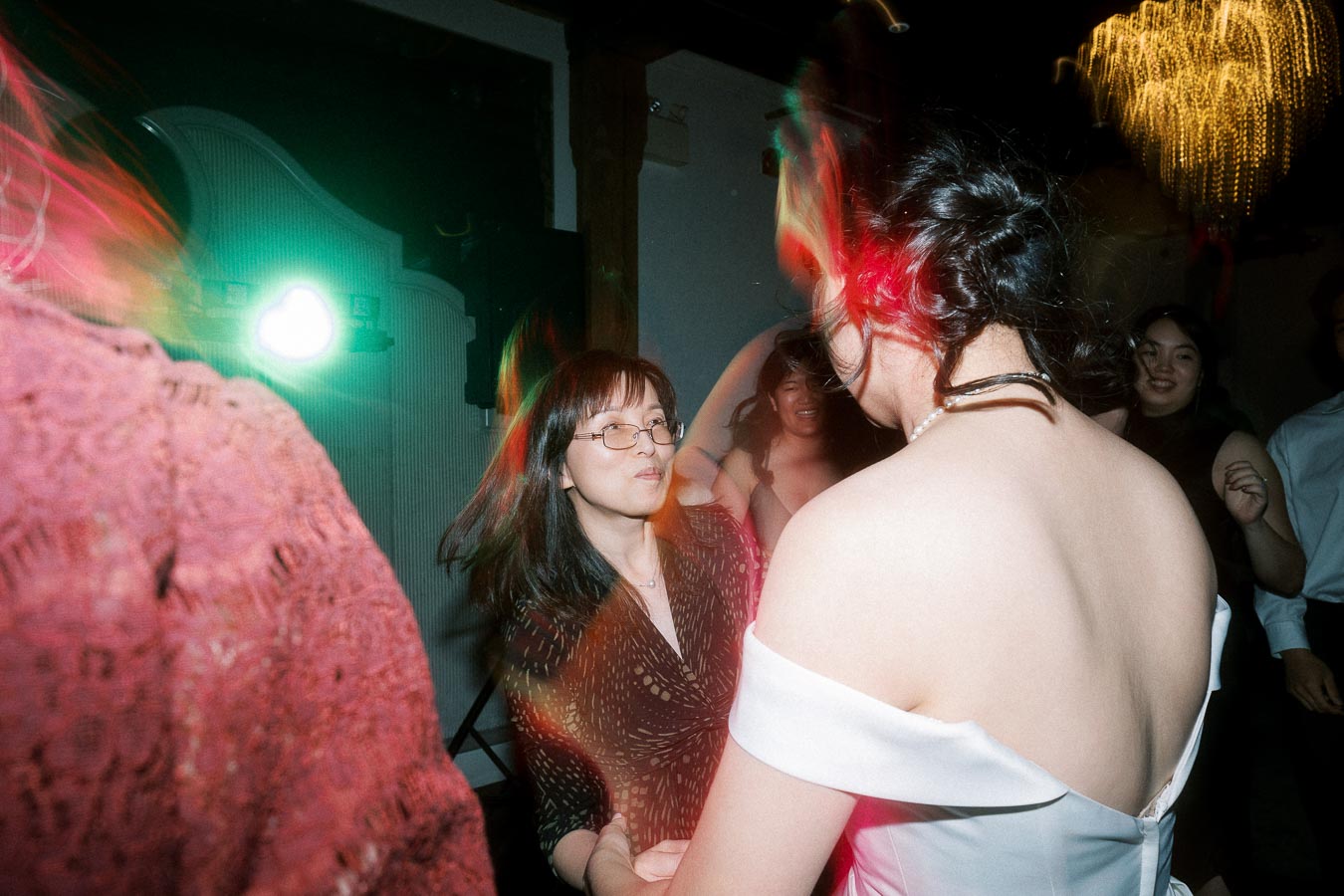 Couple dancing together at an indoor celebration with colorful party lights
