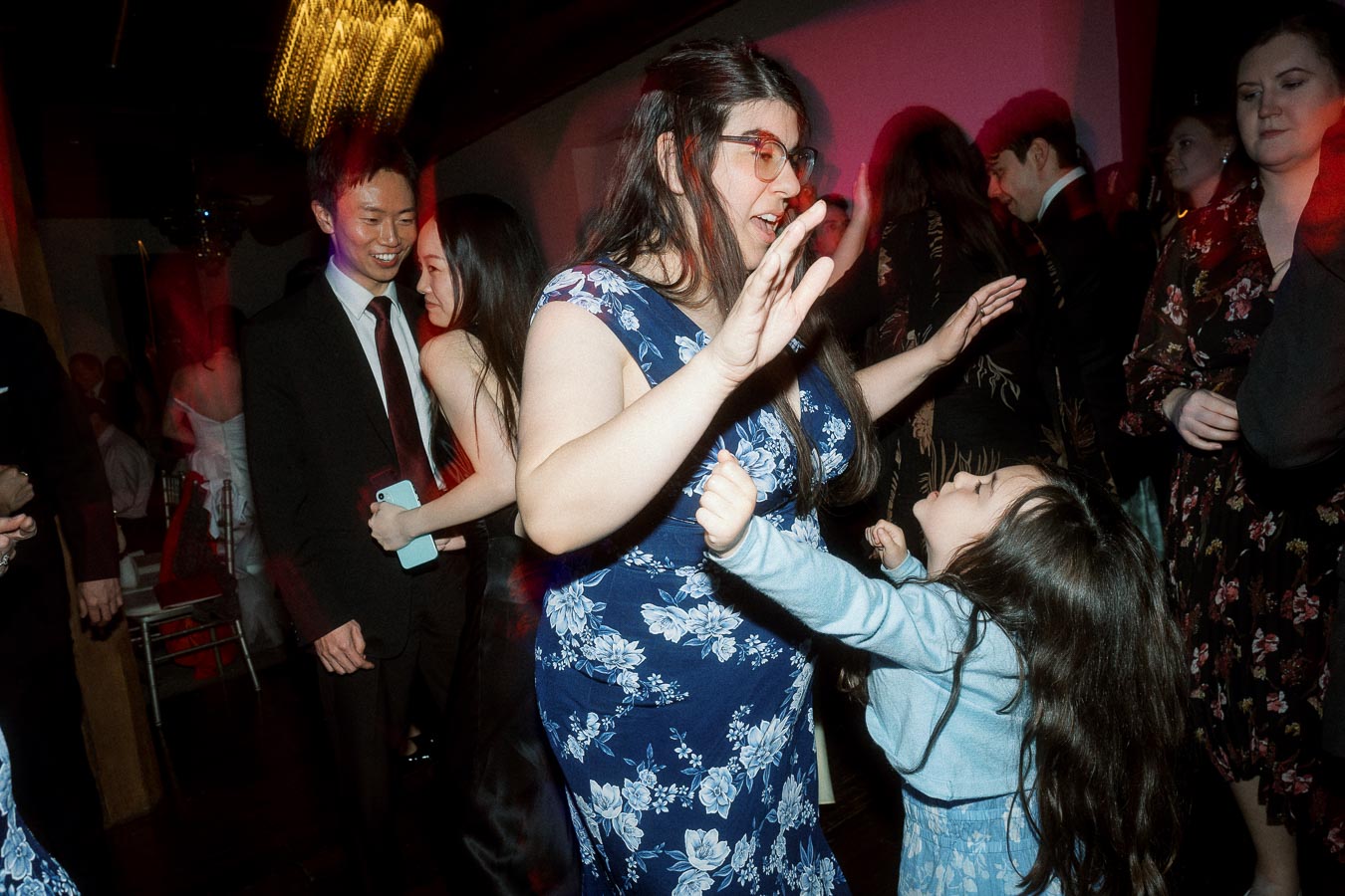 Woman and young girl dancing together at a lively indoor celebration
