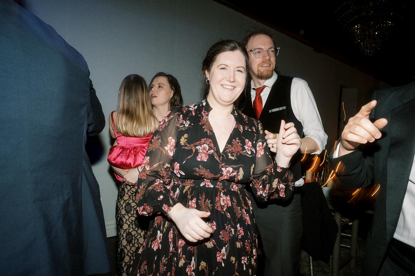Smiling guests dancing together at an indoor evening celebration