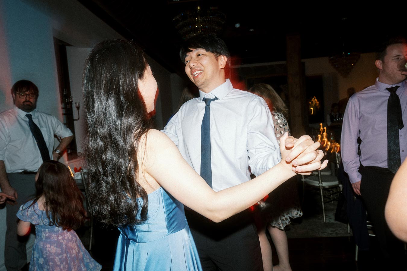 Couple smiling and dancing together at an indoor reception