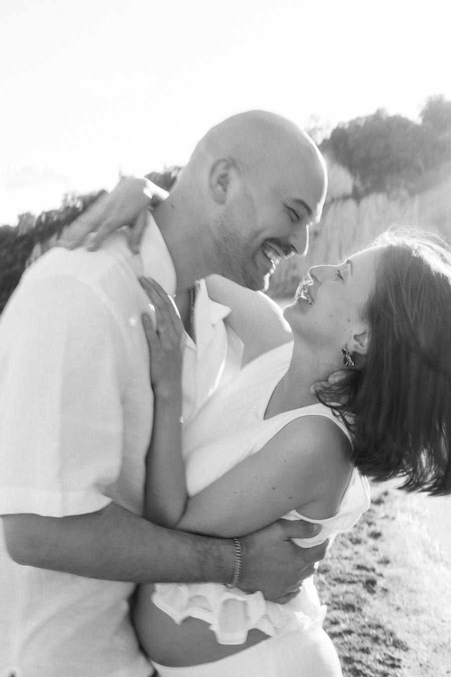 Black and white close-up of a smiling couple embracing near the Scarborough Bluffs.