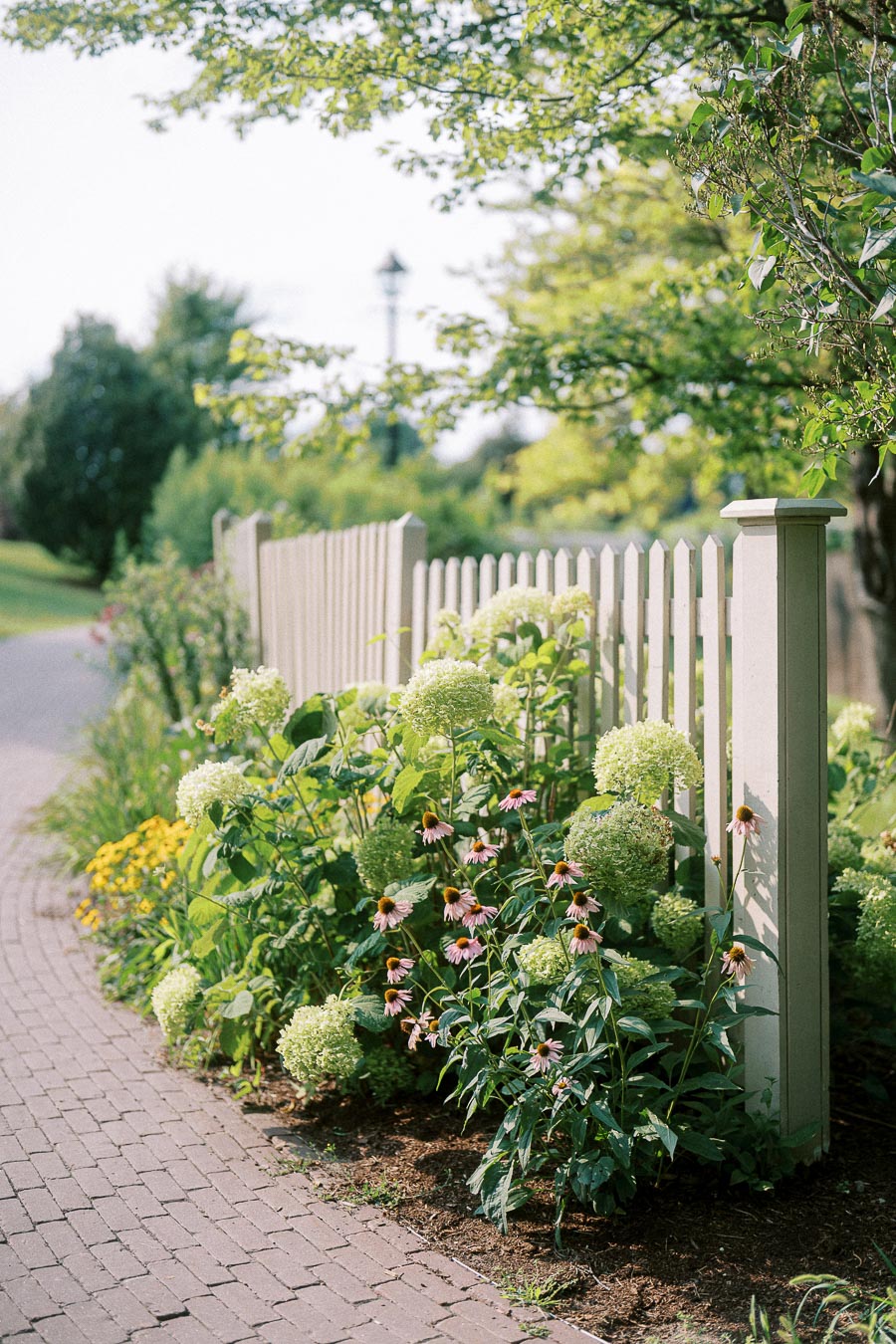 White picket fence and summer flowers at Dundurn Castle garden in Hamilton