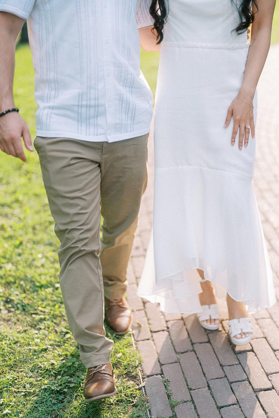 Engaged couple walking on a brick path at Dundurn Castle