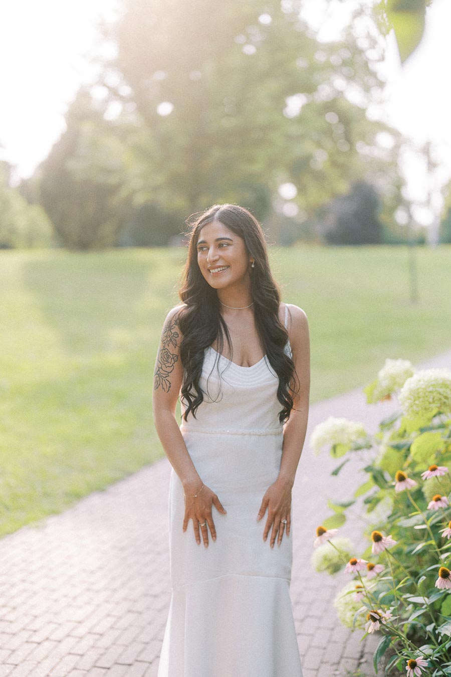 Sumbul smiling in a white dress during Dundurn Castle engagement photography