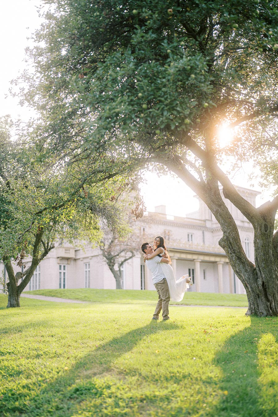 Couple lifted under trees during Dundurn Castle engagement photoshoot