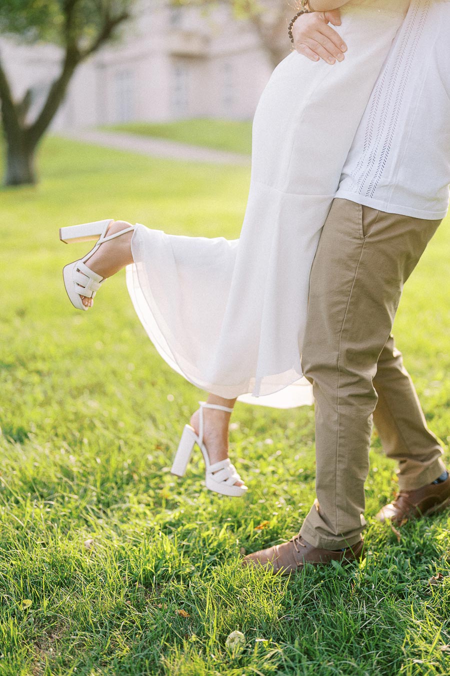 Couple embracing on grass during Dundurn Castle engagement photography session