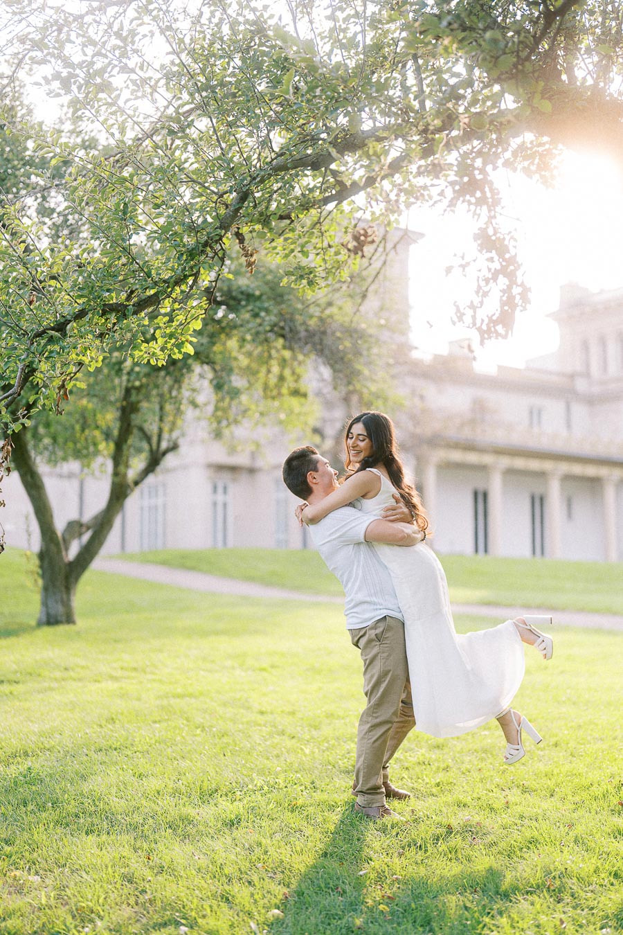 Couple embraces on Dundurn Castle lawn during a sunny engagement photoshoot