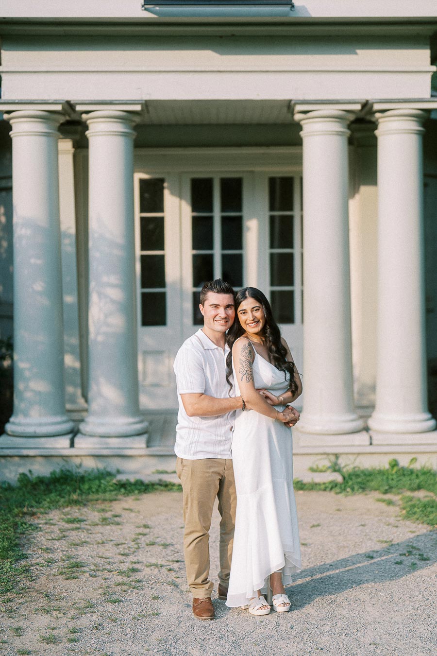 Sumbul and Brian embracing outside Dundurn Castle columns in Hamilton