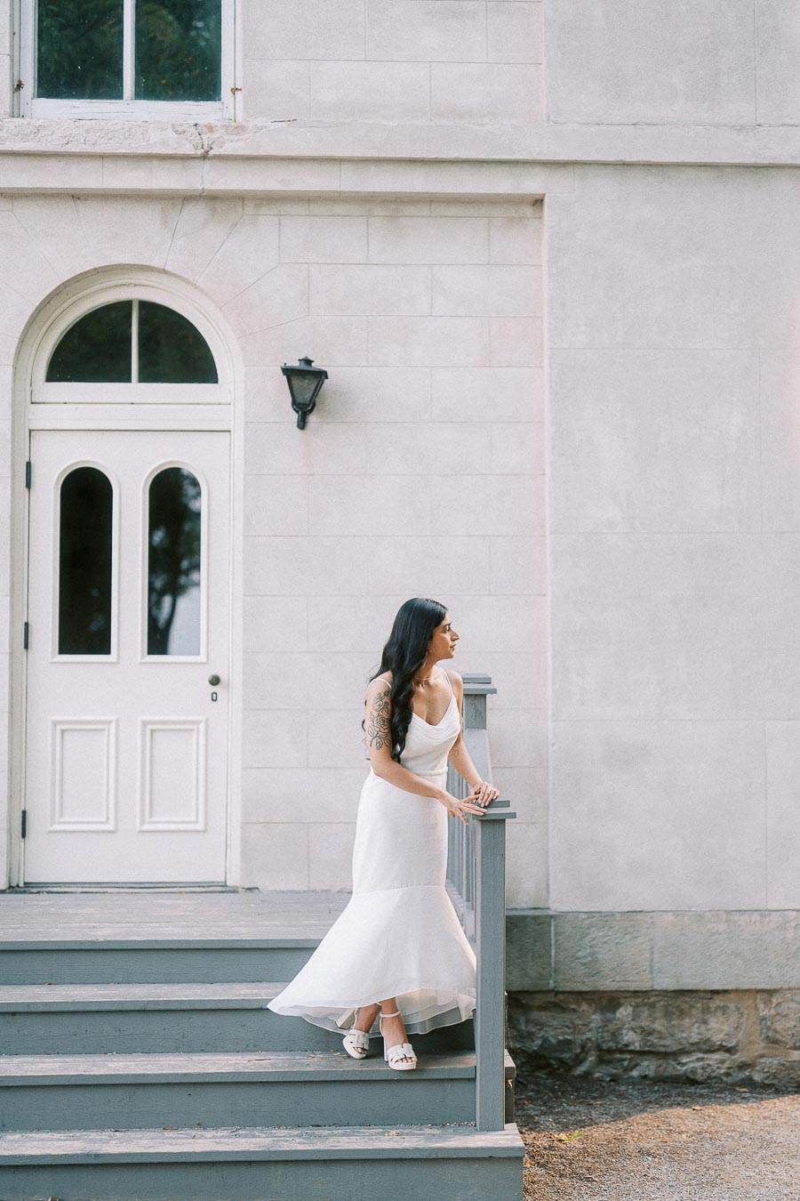 Bride-to-be on Dundurn Castle steps beside an arched white door