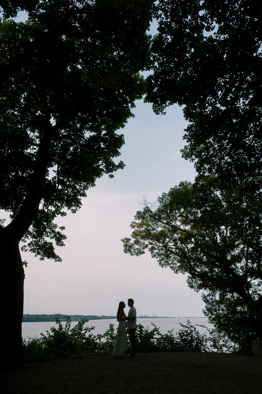 Sumbul and Brian silhouetted by Hamilton waterfront trees at Dundurn Castle