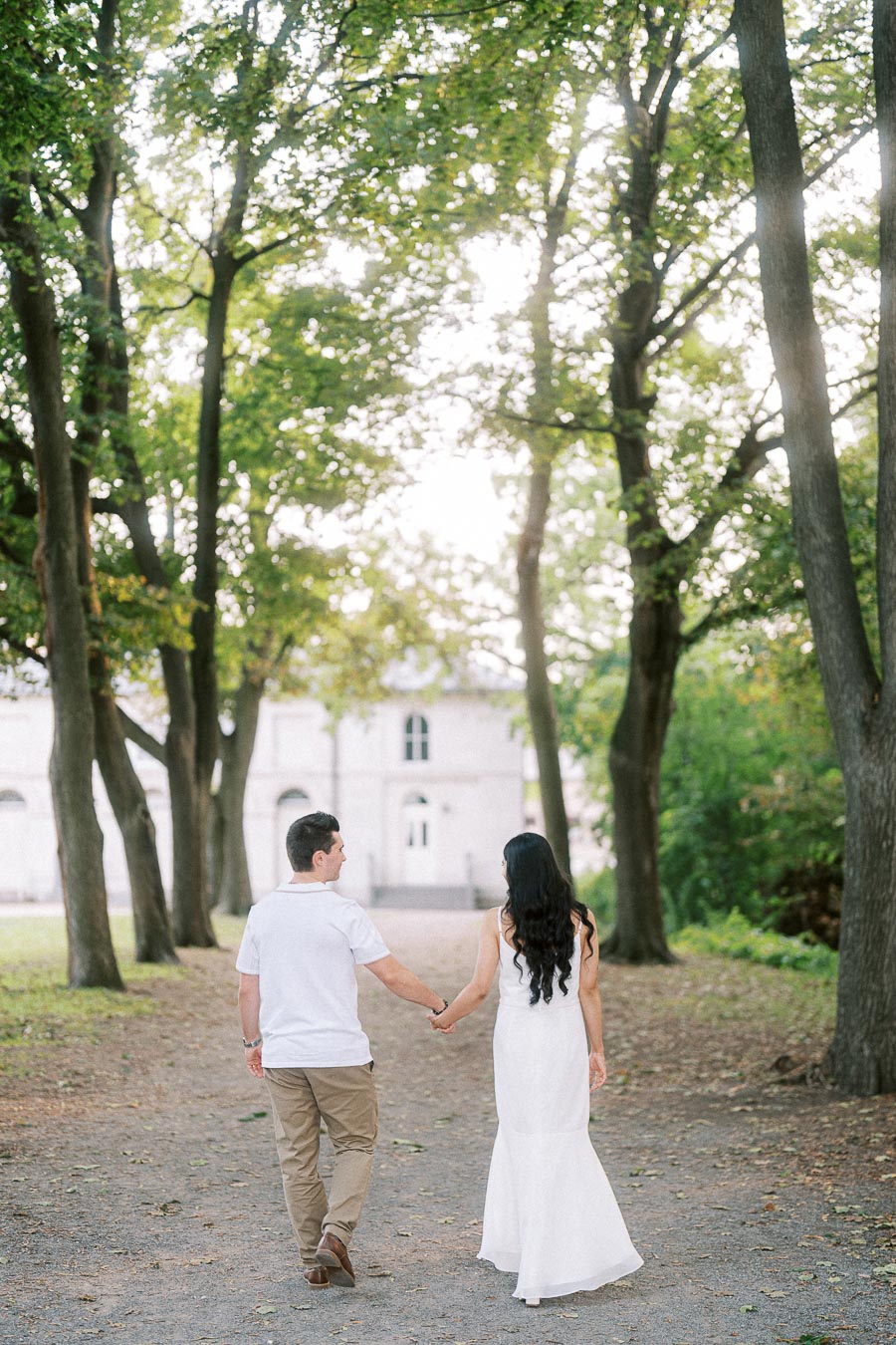 Couple walking hand in hand on a tree-lined path at Dundurn Castle