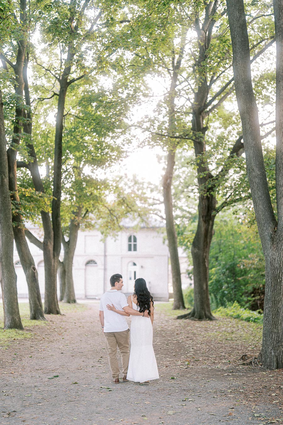 Couple walking beneath trees during Dundurn Castle engagement photoshoot