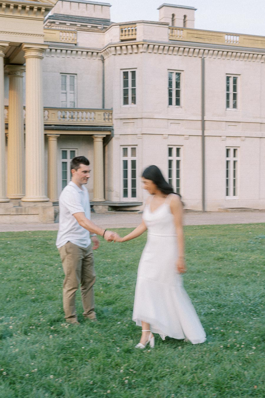 Couple holding hands on the lawn at Dundurn Castle in Hamilton