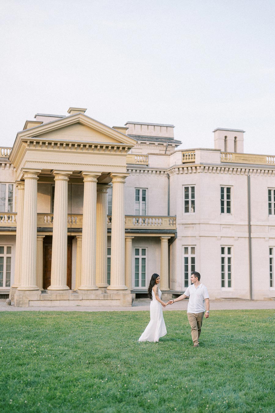 Couple holding hands on the lawn at Dundurn Castle in Hamilton