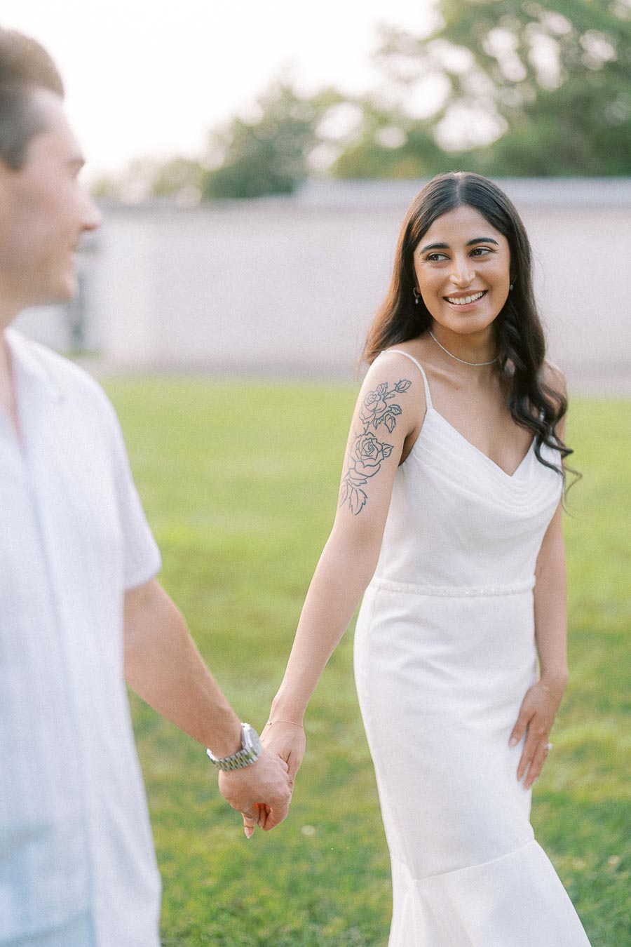 Sumbul smiling while holding Brian’s hand during Dundurn Castle engagement photos