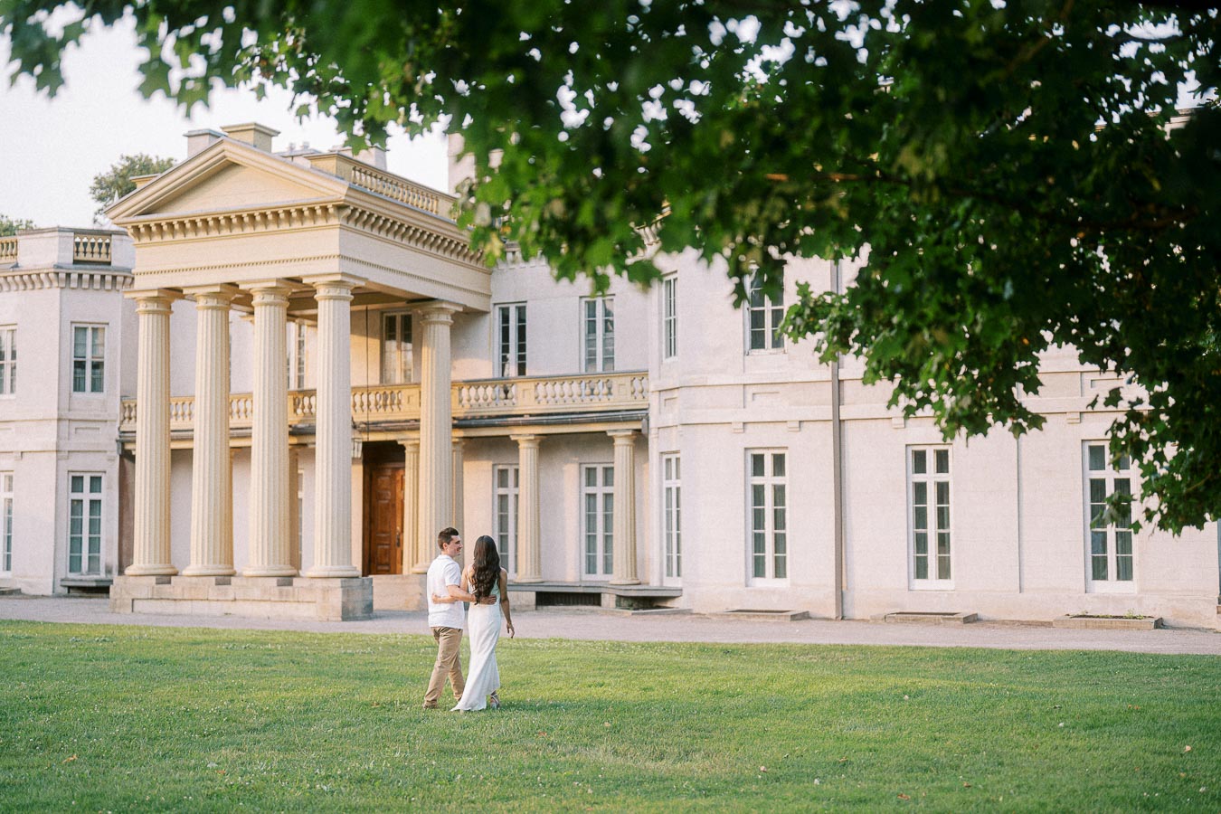 Couple walking on lawn during Dundurn Castle engagement photoshoot
