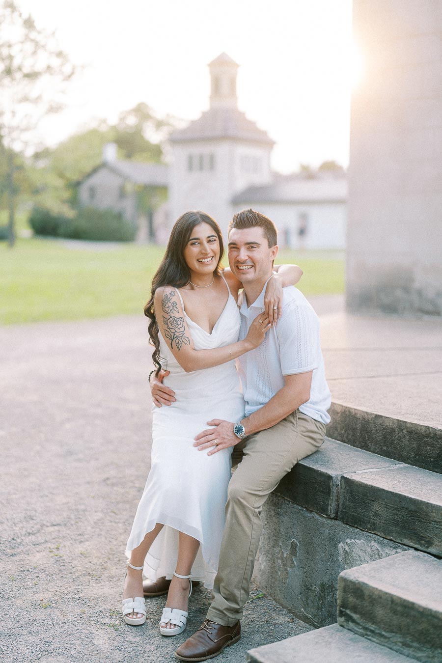 Sumbul and Brian seated on stone steps at Dundurn Castle engagement session