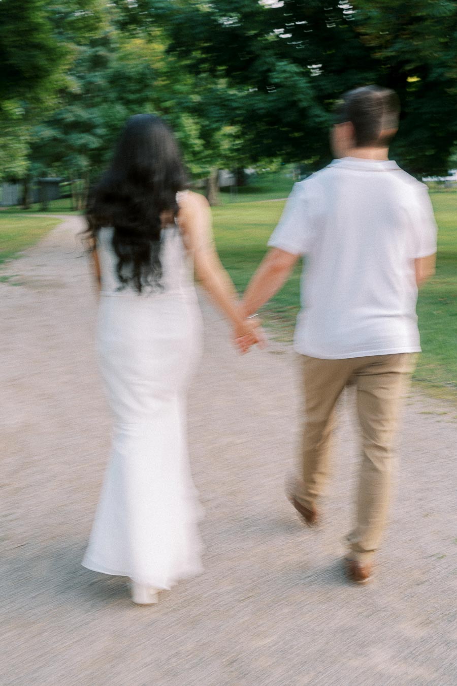 Couple holding hands on a tree-lined path at Dundurn Castle in Hamilton