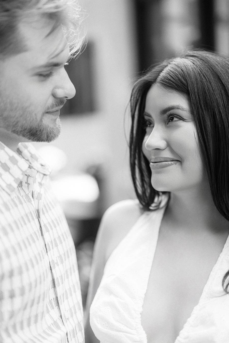 Black and white close-up engagement portrait of a couple looking at each other.