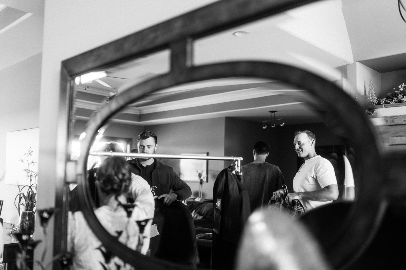 Men reflected in a mirror while gathering indoors before a wedding