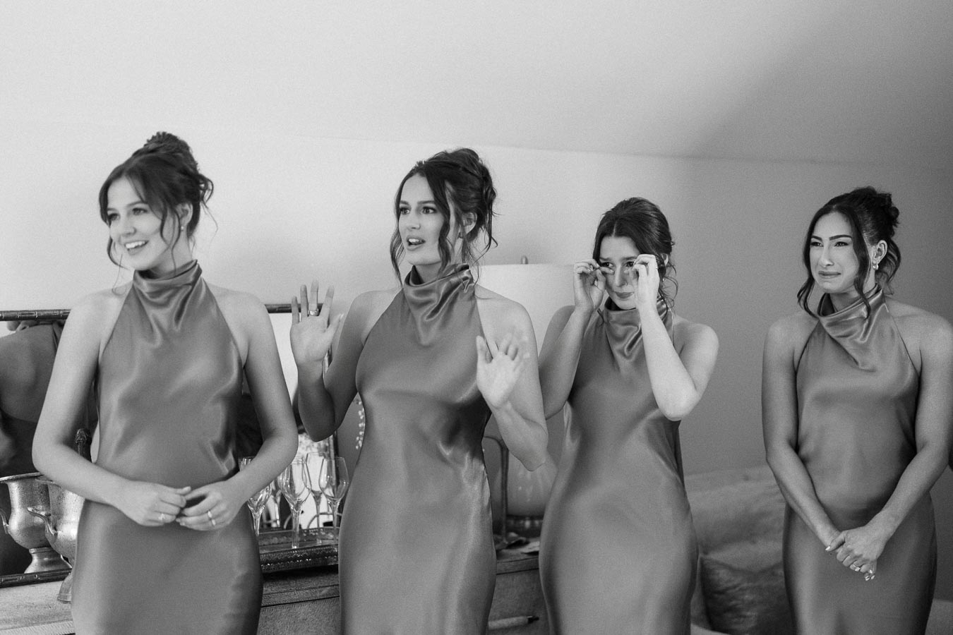 Four bridesmaids in matching satin dresses react emotionally during a wedding morning at a private farm estate near Chatham-Kent, Ontario.