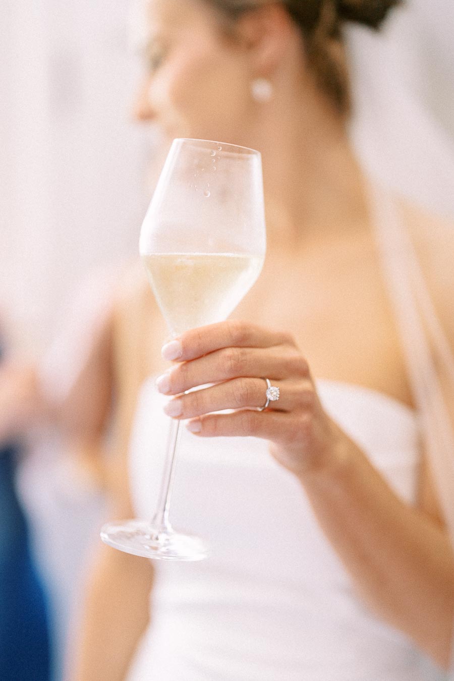 Bride holding a champagne flute with engagement ring visible during wedding morning near Chatham-Kent, Ontario, Canada.