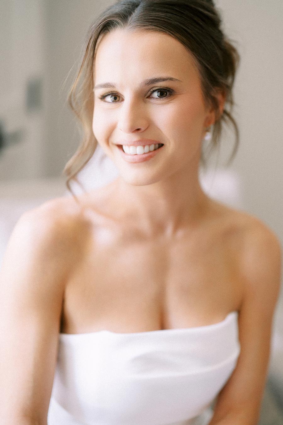 Smiling bride in a white strapless wedding dress during bridal morning preparations near Chatham-Kent, Ontario, Canada.