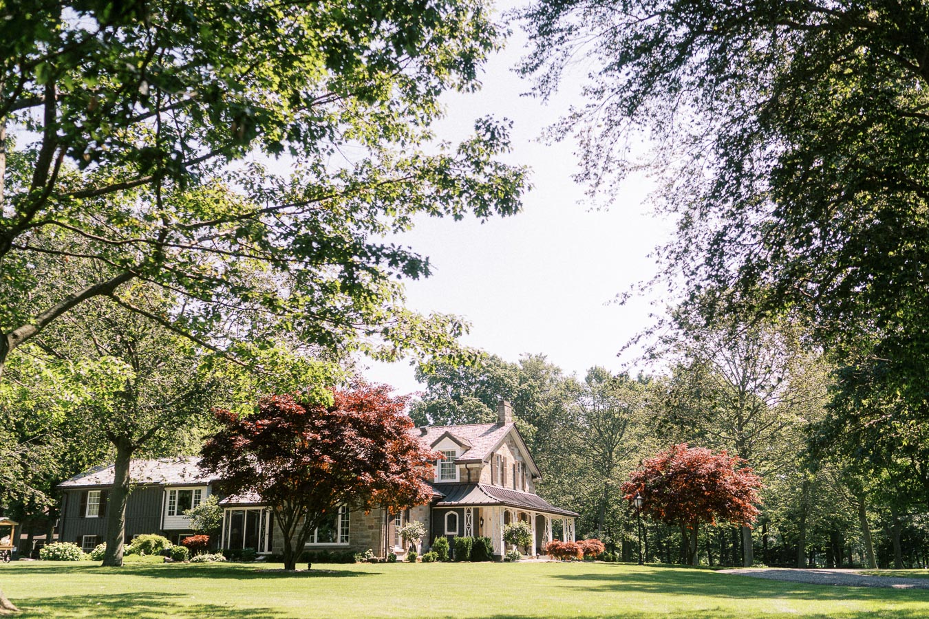 Private estate farmhouse with lawn and trees near Chatham-Kent, Ontario, Canada, outdoor setting for a farm wedding morning.
