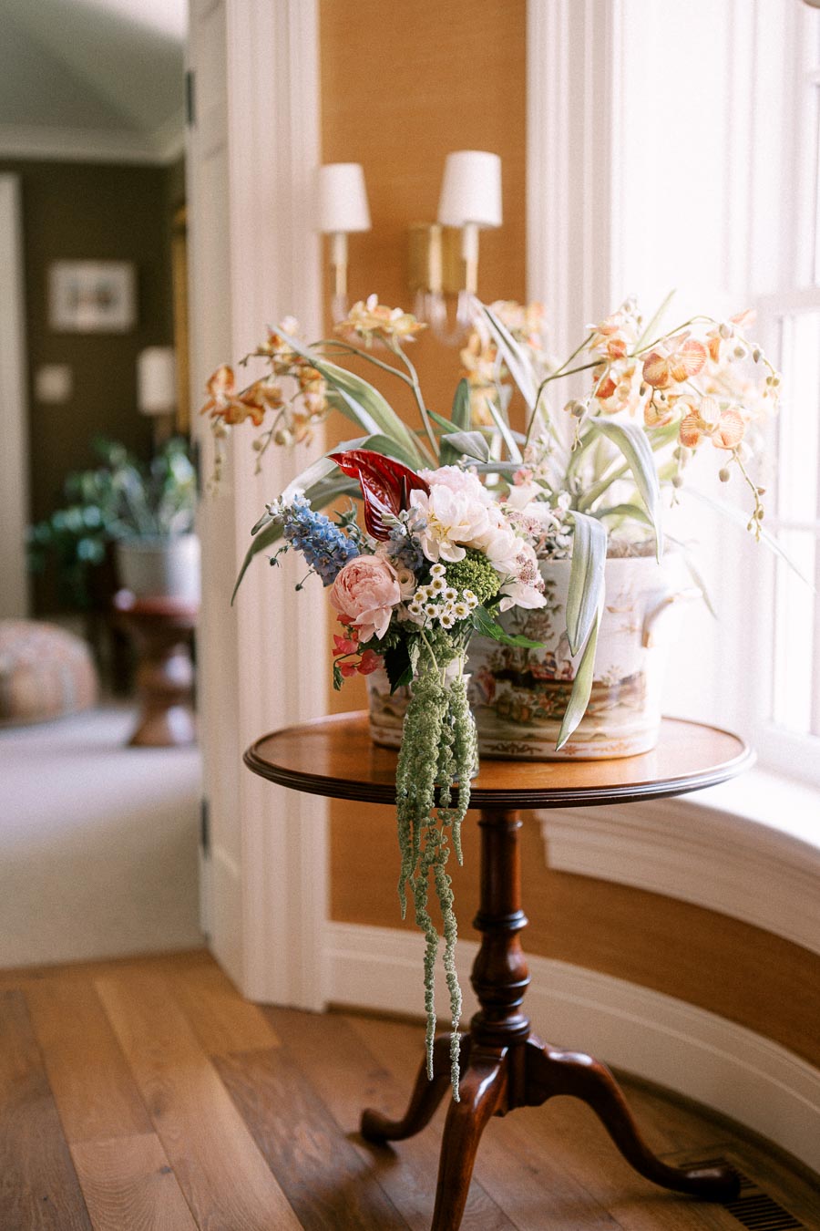 Floral arrangement on a wooden pedestal table by a bright window inside a home near Chatham-Kent, Ontario.