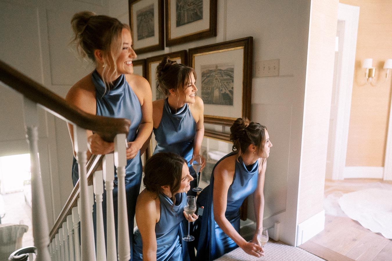 Four bridesmaids in blue satin dresses gather on a staircase during a wedding morning at a private farm estate near Chatham-Kent, Ontario.