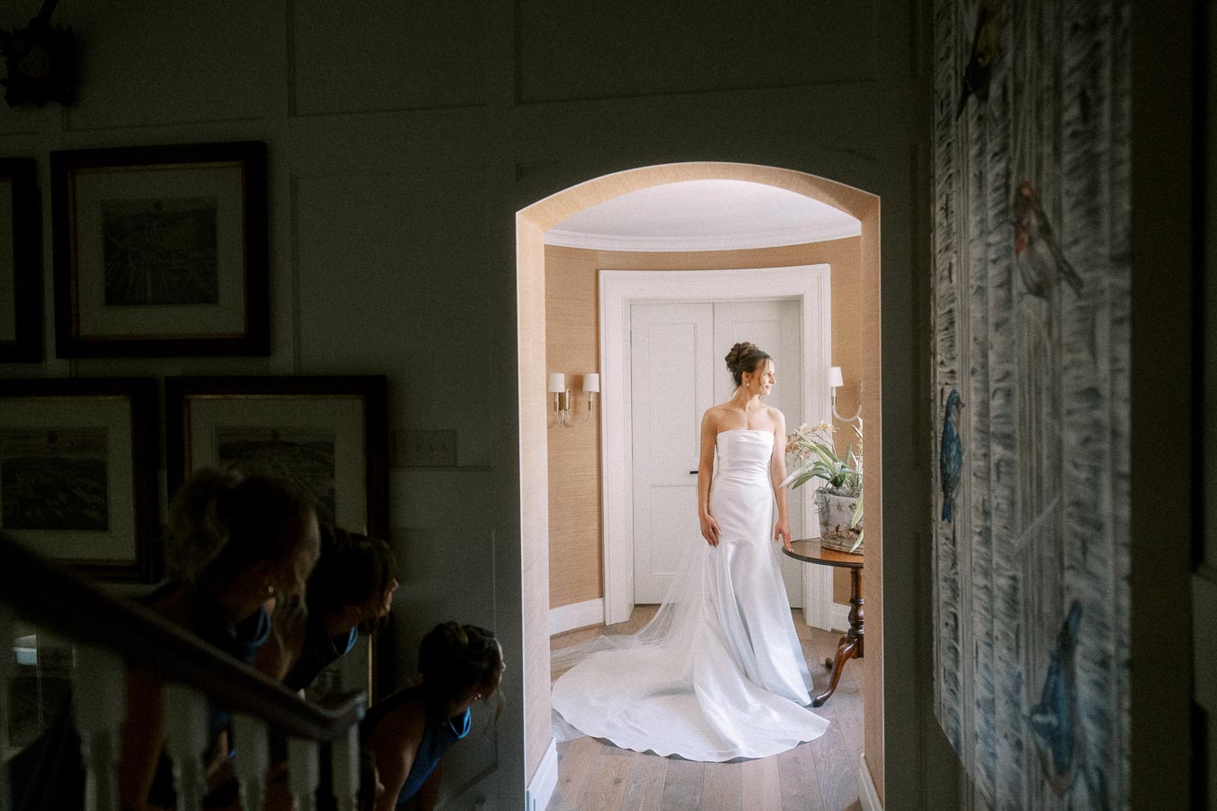 Bride in a strapless white wedding dress standing in an arched doorway inside a farmhouse near Chatham-Kent, Ontario.