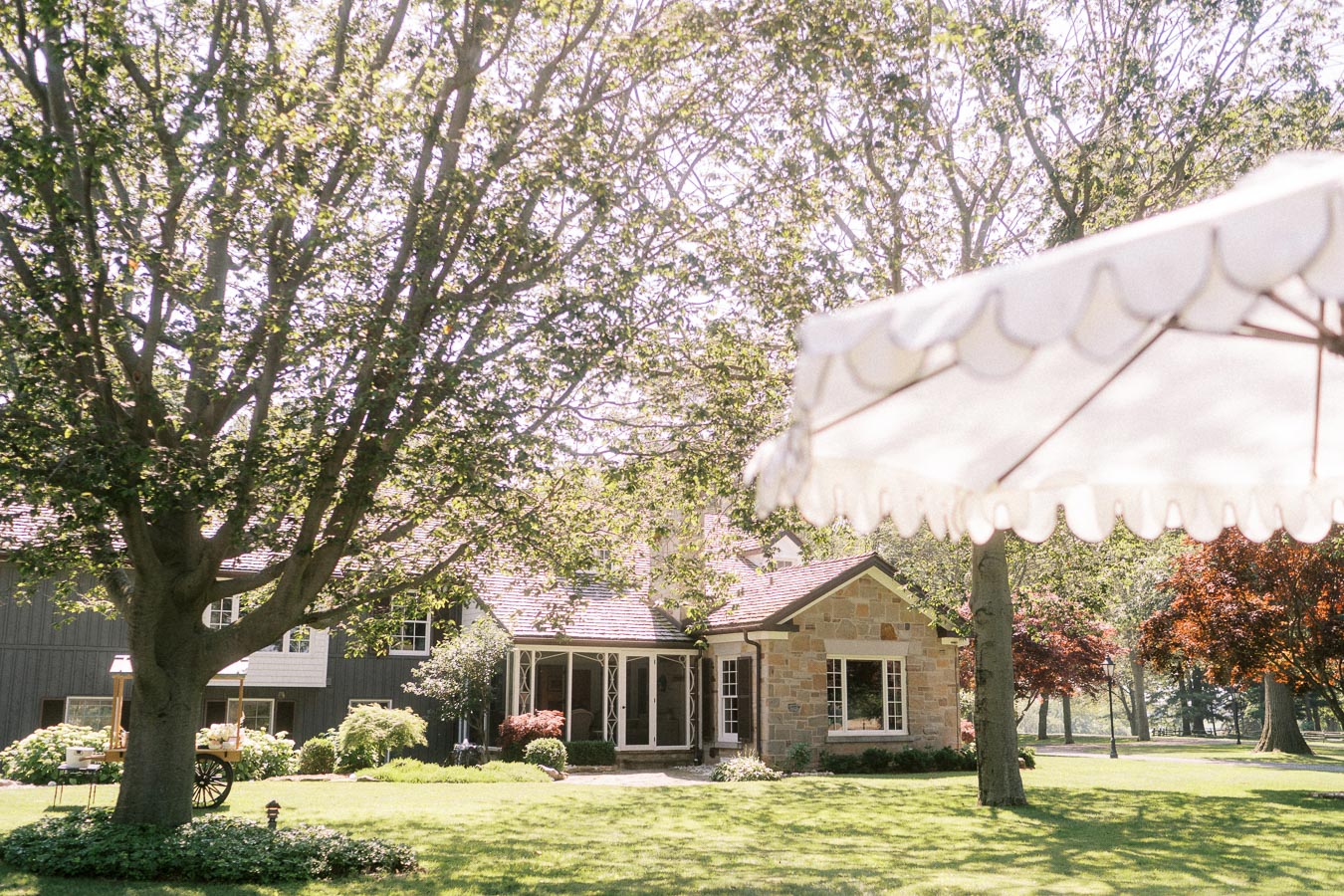 Private estate lawn with stone house, large trees, and white wedding tent canopy near Chatham-Kent, Ontario.