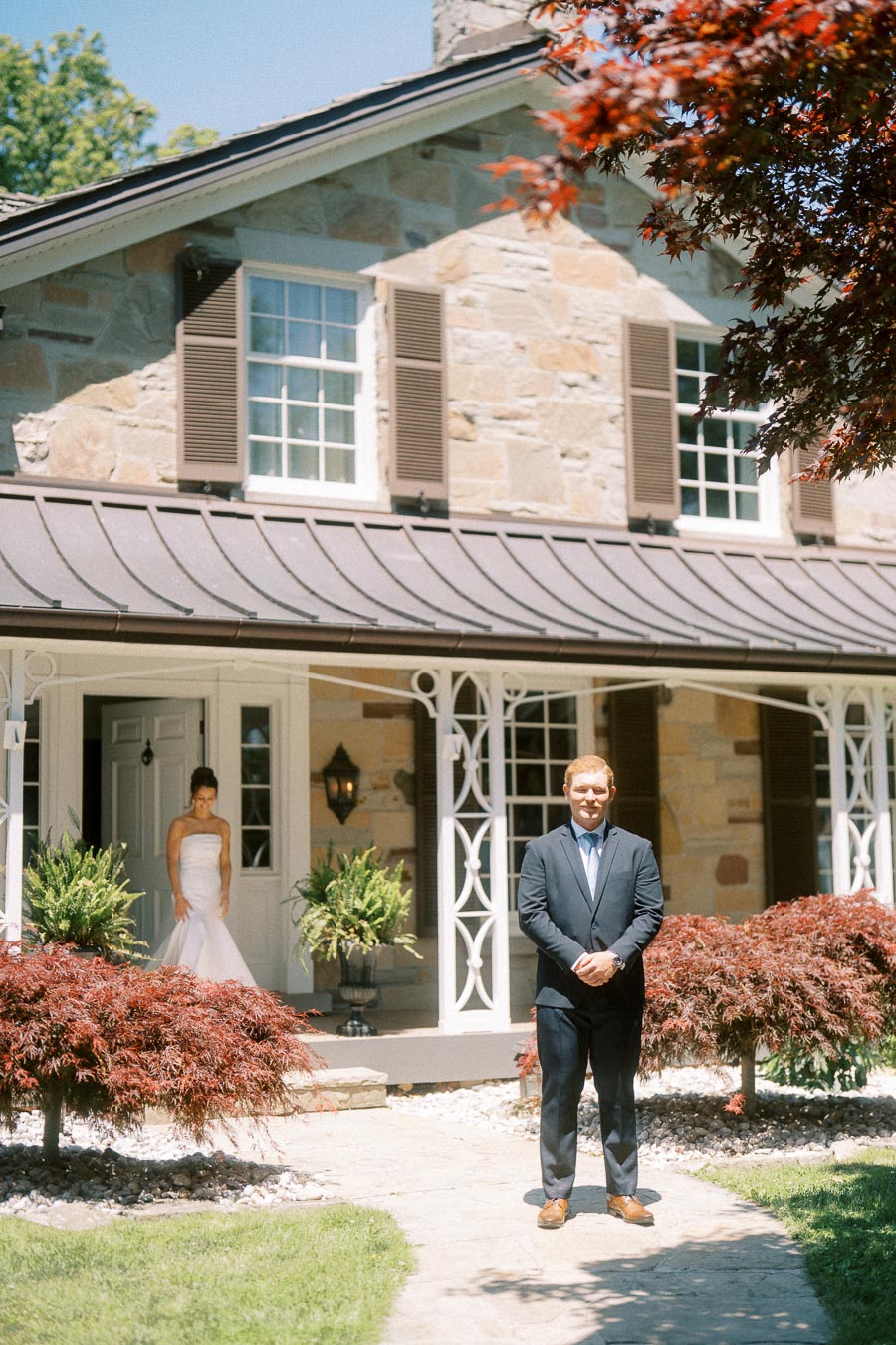 Bride approaches groom for a wedding first look outside a stone private estate near Chatham-Kent, Ontario.